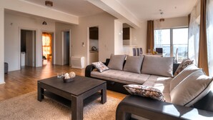 A spacious living area with a sofa, coffee table, and a view of the outdoors. - Sea View Apartments MonteBook (Becici)