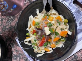 Uma tigela de prato com macarrão, vegetais e tofu.