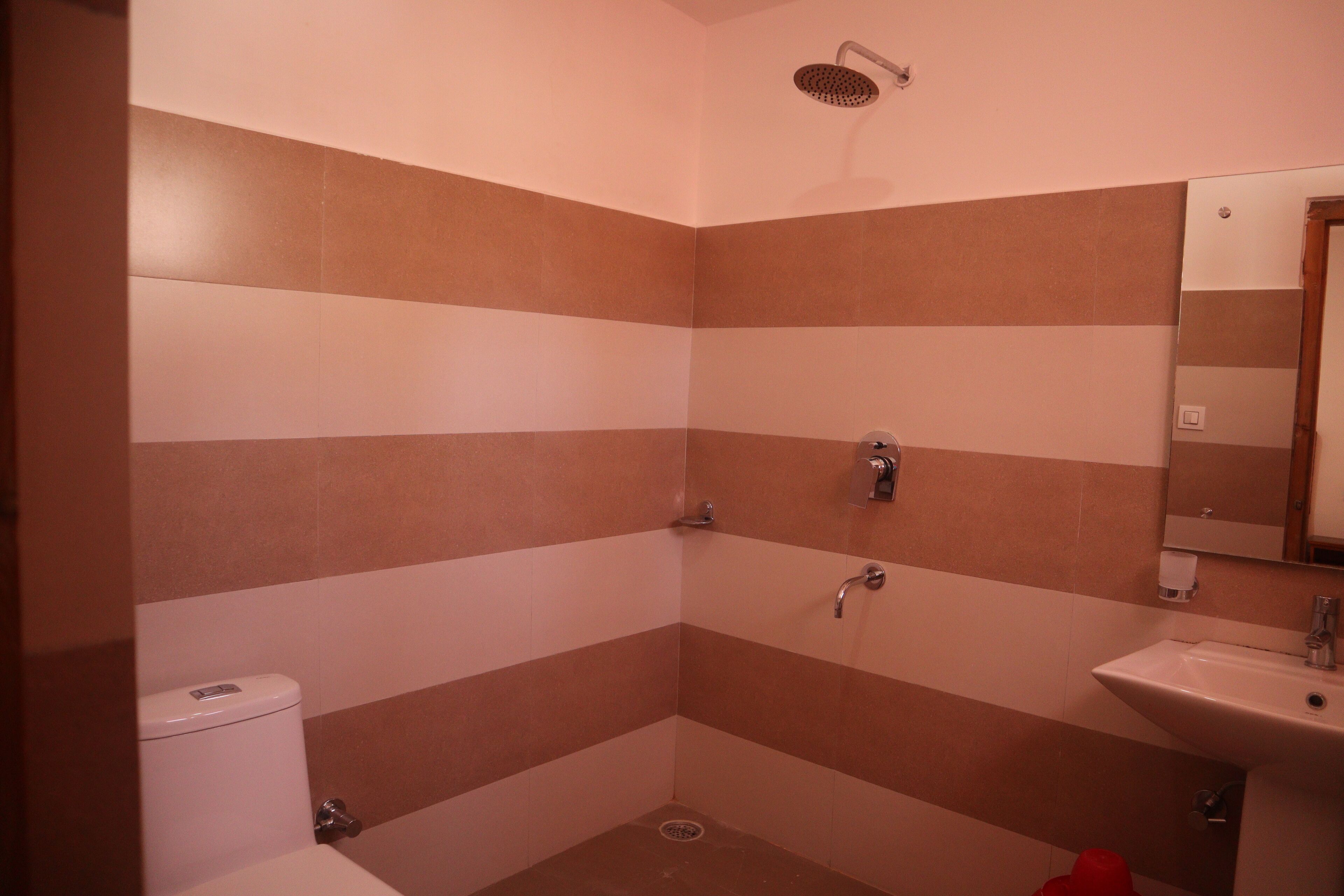 Un bagno con pareti a righe, una doccia, un water e un lavandino.