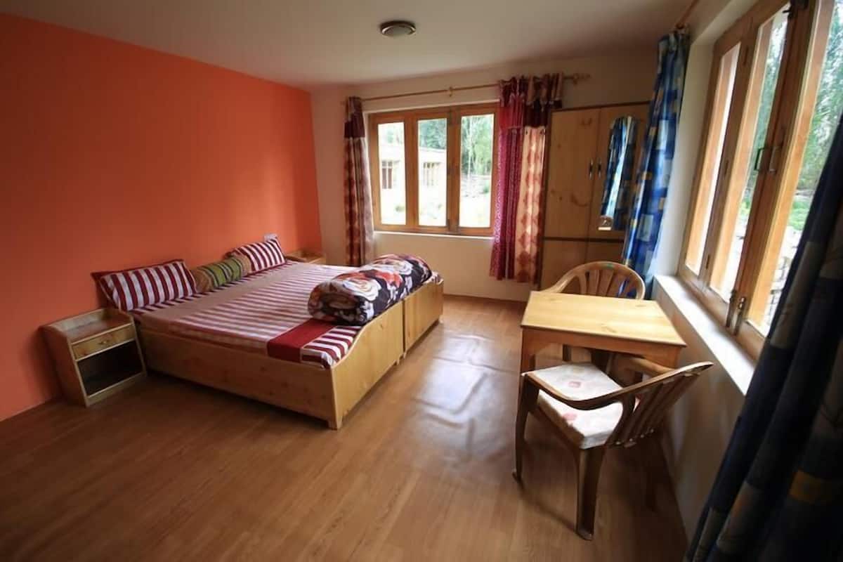A room with a bed, a table, and a chair.