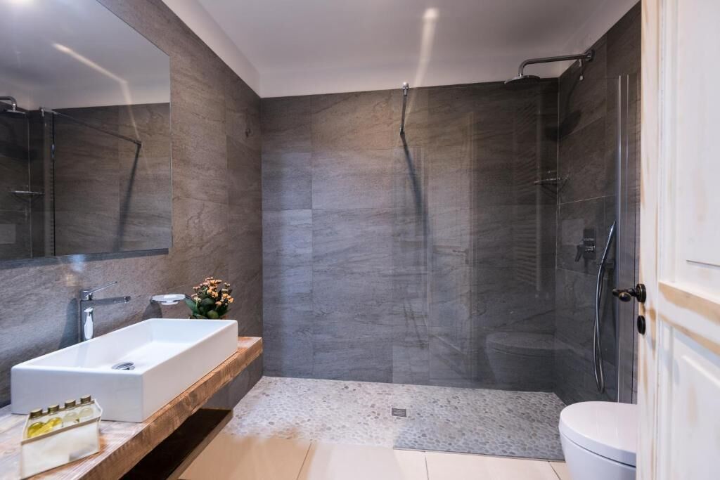 A modern bathroom with a rectangular sink, a glass shower enclosure, and a toilet.