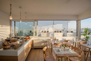 Un comedor moderno con ventanas amplias, una barra de cocina y muebles de madera.
