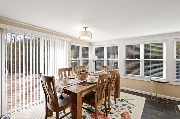 A dining room with a wooden table, chairs, and a decorative rug. - Nestled in a secluded woods, this charming cottage is close to Dollywood 😃 (Sevierville)