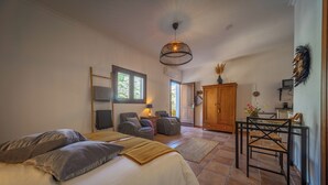A spacious bedroom with a large bed, a sitting area with a table and chairs, and a view of the outdoors. - Boutique B&B Casa La Calera 15+/ Caminito del Rey-15 min/Ronda-25 min/Town-5 min (Teba)