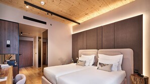 Ein modernes Schlafzimmer mit zwei Betten, einem Holztisch und einem Stuhl.