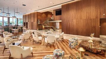 Un vestíbulo amplio con piso de madera, muebles modernos y una escalera que lleva a un nivel superior.