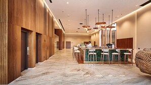 Eine moderne Bar mit Marmorboden, Holzwandverkleidung und einer Bar mit Hockern.