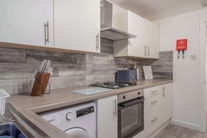 A modern kitchen with white cabinets, a built-in oven, a dishwasher, and a gas stove. - 3BR Near Glasgow | Free Parking | Ideal for Work (East Kilbride)