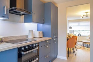 Une cuisine moderne avec des meubles gris, un four encastré et un grille-pain.