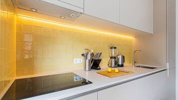 A modern kitchen with a built-in stove, a sink, and a coffee maker.