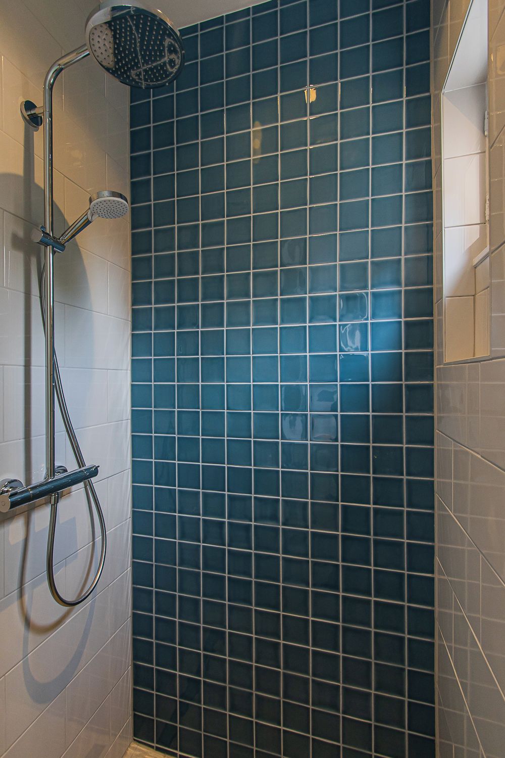 Een douche met een handdouche en een kraan op de muur.