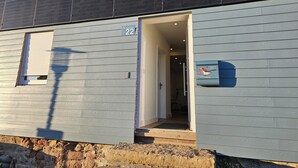 A building with a number 22 sign, a mailbox with a bird illustration, and a door leading to an interior space. - "Farbzauber Blau" in Harz Thore, featuring a sauna, balcony, hot tub, and bike shed (Sankt Andreasberg)