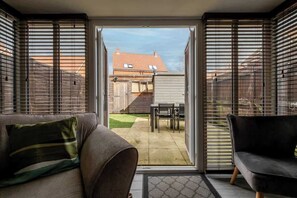 Ein Zimmer mit einer Schiebetür und Zugang zu einer Außenpatio-Terrasse.