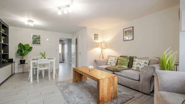 Un salon moderne comprenant un canapé, une table basse et un coin repas avec des chaises et une table.