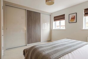 Un dormitorio con cama, un armario amplio y una ventana con vistas.