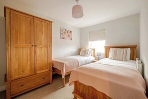 Ein Schlafzimmer mit zwei Einzelbetten, einem Holzschrank und einer Deckenleuchte.