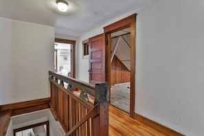Staircase with handrail and door leading to another room.