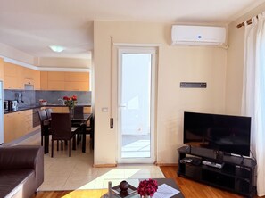 A modern apartment with a kitchen, dining area, living room, and a balcony.