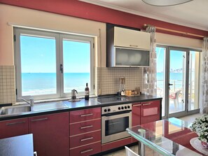 A kitchen with a view of the sea, a stove, and a sink. - Dream View Apartment Durres 119 (Durres)
