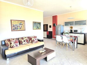 Un salon comprenant un canapé, une table basse et un coin repas avec des chaises et une table.