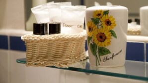 Ein Korbwäscher und eine Keramiktasse mit Sonnenblumen auf einem Glastisch.