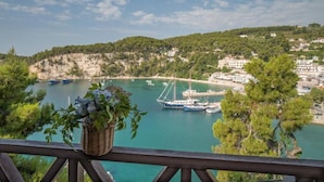 A coastal view with boats docked at a marina, surrounded by greenery and buildings. - Liadromia Hotel (Alonissos)