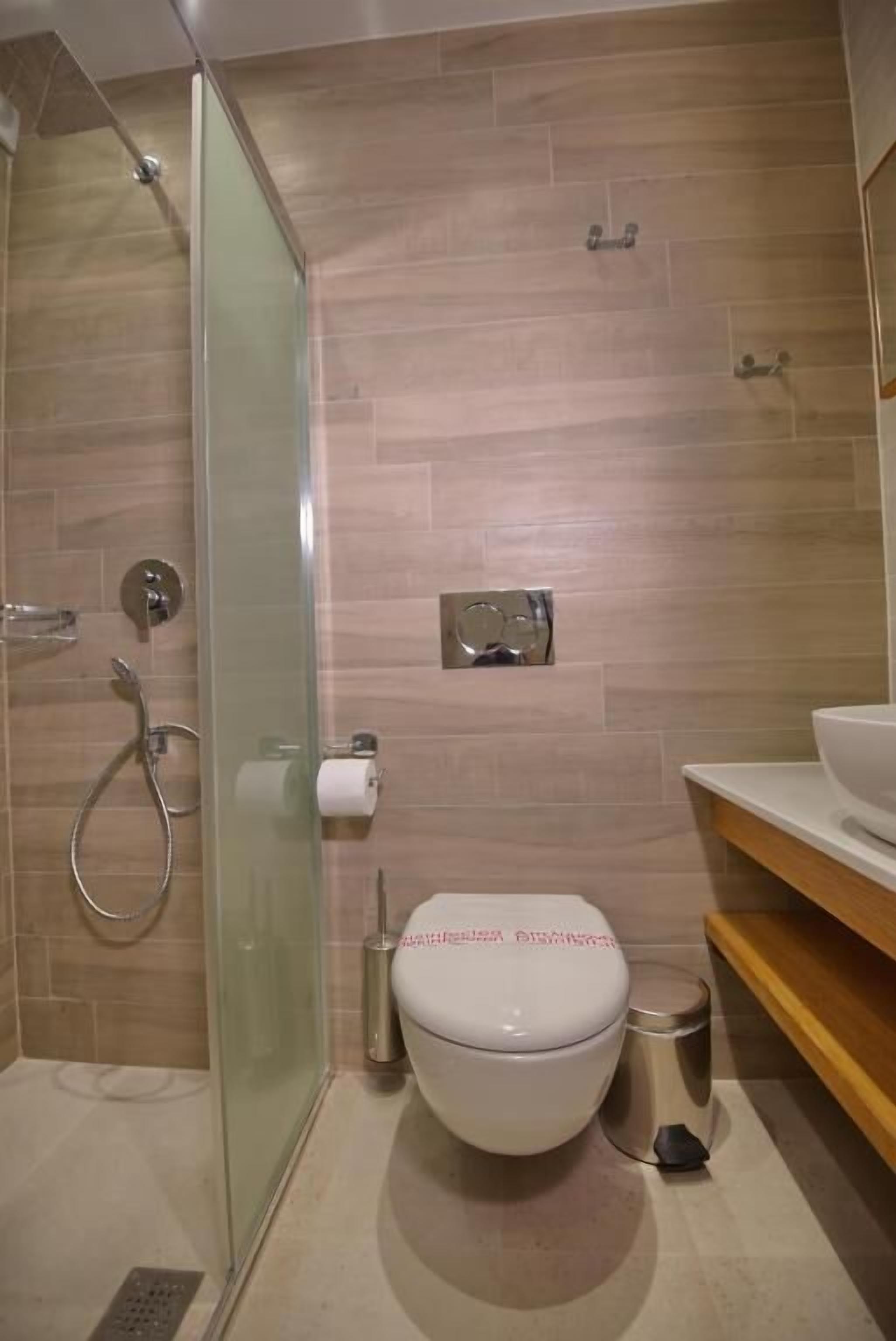 Un baño moderno con ducha de vidrio, inodoro y lavabo.