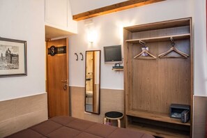 A hotel room with a bed, a wooden wardrobe, a mirror, a television, and a framed picture on the wall. - Saint Peter Rome B&B: Double Economy (Roma)