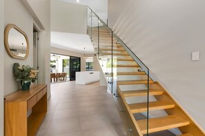 Un interno moderno con una scalinata, una reception e vista sull'area living.