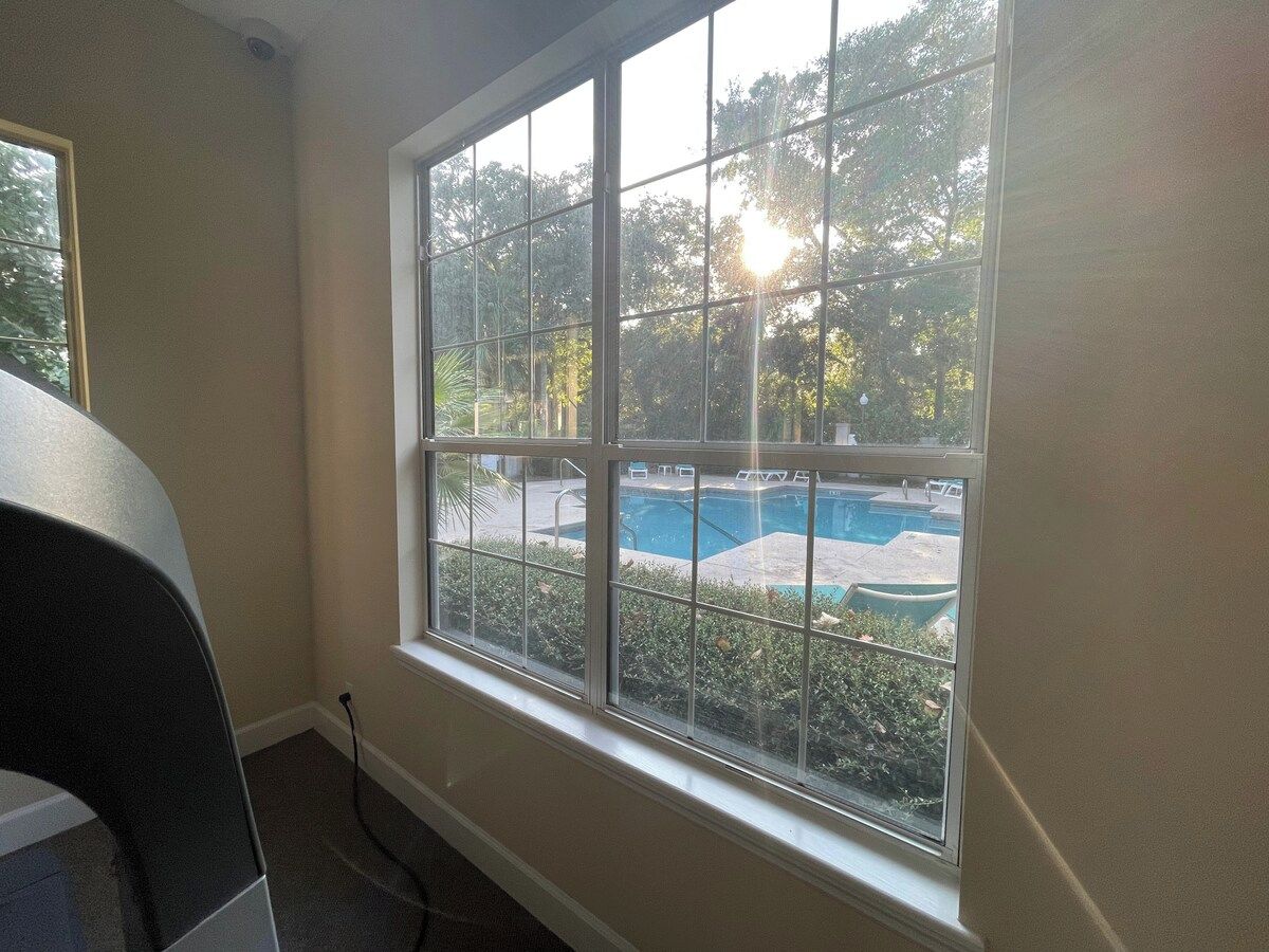 Una habitación con un ventanal grande que da a una piscina.