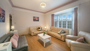 A living room with two sofas, a coffee table, and a painting on the wall. - Constancevilla B9 | Grampian Lettings Ltd (Bucksburn)