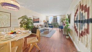 A spacious living room with a dining area, large windows, and a view of the outdoors.