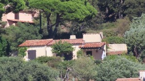 A hillside village with traditional buildings featuring terracotta roofs and white walls.
