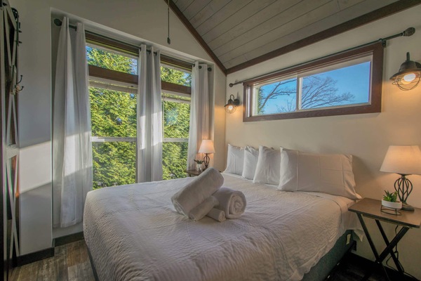 Wake up to natural light and lush views in this inviting bedroom.