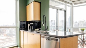 Una cocina moderna con lavavajillas, cafetera y lavabo.
