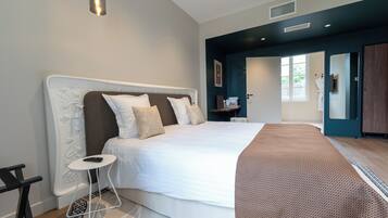 A modern bedroom with a large bed, a bedside table, and a built-in wardrobe.