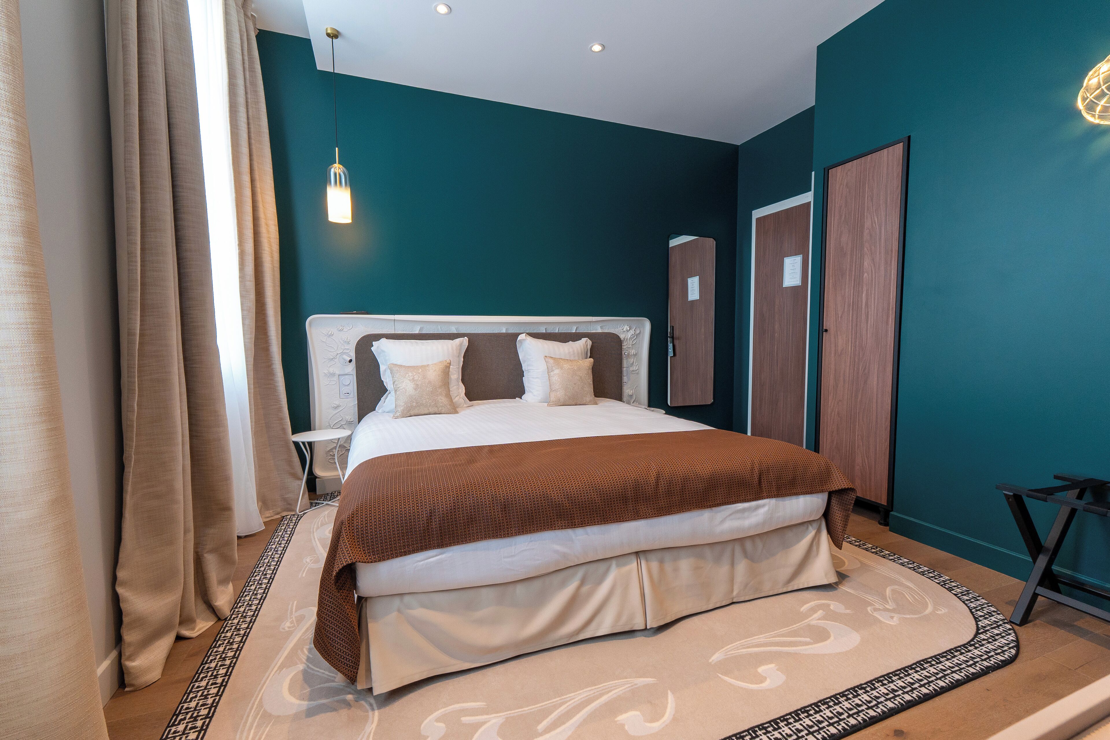 Een moderne slaapkamer met een groot bed, een nachtkastje en een kledingkast.