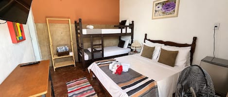 Habitación con literas, escritorio, ventilador y un cuadro en la pared.