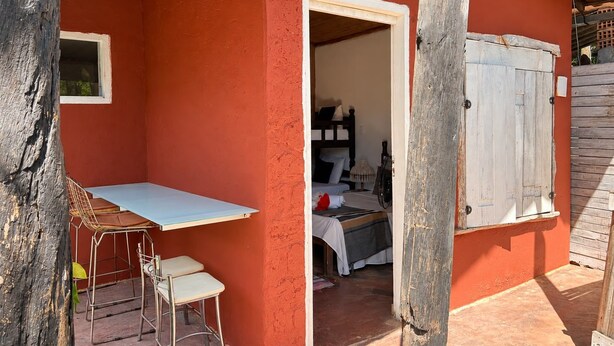 A small room with a single bed, a wooden door, and a window. - Pousada Princesa da Serra (Santana do Riacho)
