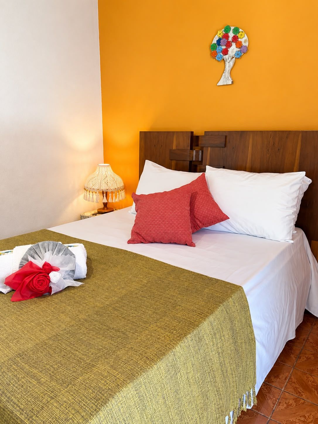 Una habitación de hotel con una cama, una mesita de noche con una lámpara y un adorno en la pared.