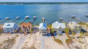 A coastal property with multiple buildings, docks, and boats. - Lux 6BR, Lagoon Front, Private Heated Pool, Gulf Views, Boat Dock, Walk To Beach (Gulf Shores)