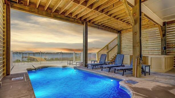 A swimming pool with lounge chairs and a view of the sunset. - Lux 6BR, Lagoon Front, Private Heated Pool, Gulf Views, Boat Dock, Walk To Beach (Gulf Shores)