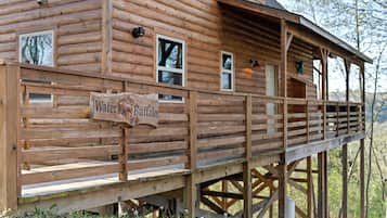 En stuga byggd av trästockar med en veranda och en skylt som visar texten ”Water Buffalo”.