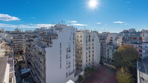 A high-rise building with multiple balconies and a basketball court in the courtyard.