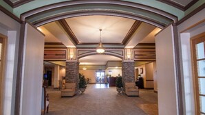 A spacious lobby with a high ceiling, stone pillars, and a chandelier. - The Androy Hotel - Superior Duluth (Superior)
