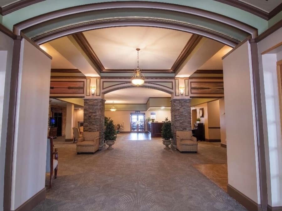 A spacious lobby with a high ceiling, stone pillars, and a chandelier.
