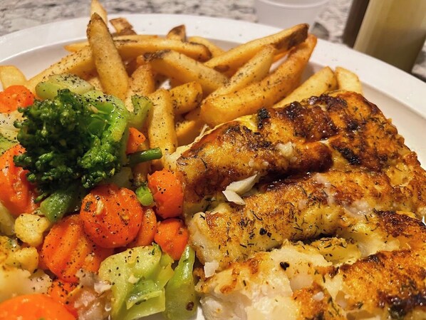 A plate with grilled fish, fries, and mixed vegetables. - The Androy Hotel - Superior Duluth (Superior)