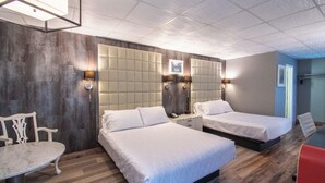 A hotel room with two beds, a small table, a chair, and a desk. - The Androy Hotel - Superior Duluth (Superior)