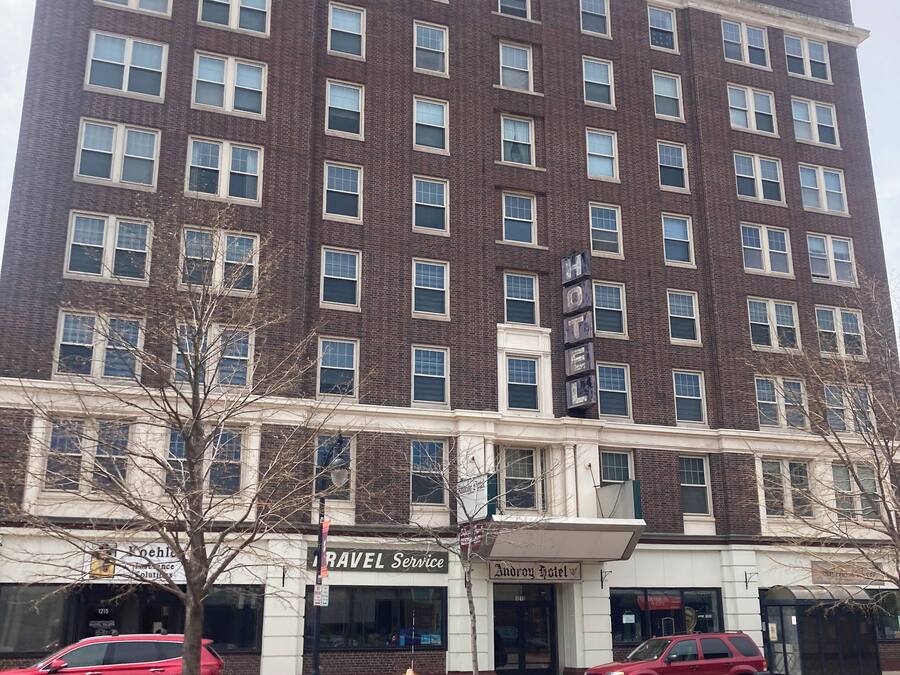 A multi-story hotel with a brick facade, multiple windows, and a sign for 'Andover Hotel'.