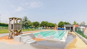 A swimming pool with a wooden structure and steps leading into the water. - 16 - Le Colibri - Village vacances (Maché)